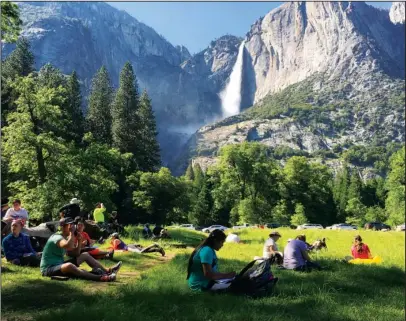  ?? The Associated Press ?? YOSEMITE FALLS: A class of eighth grade students and their chaperones sit in a meadow on May 25 at Yosemite National Park, Calif., below Yosemite Falls. Officials fear a surge in drownings following record snowfall this winter as the weather heats up...