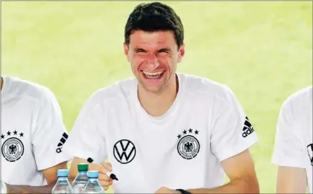  ?? AFP ?? Germany’s striker Thomas Mueller smiles during an autograph-signing session with supporters after their training on June 26.