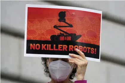  ?? Photograph: Jeff Chiu/AP ?? A woman holds up a sign while taking part in a protest about the use of robots by the SFPD.