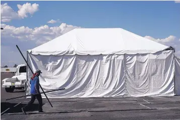  ?? ADOLPHE PIERRE-LOUIS/JOURNAL ?? Jorge Miramontes sets up a concession tent at the Balloon Fiesta Park in preparatio­n for Wednesday’s Freedom Fourth event.