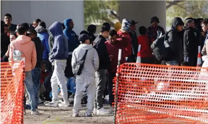  ?? ?? People who have crossed the US-Mexico border wait to board a bus in Eagle Pass, Texas, on Wednesday. Photograph: Adam Davis/EPA