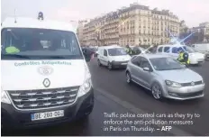  ?? — AFP ?? Traffic police control cars as they try to enforce the anti-pollution measures in Paris on Thursday.