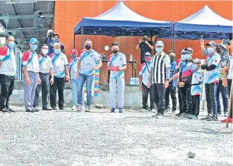  ??  ?? Andi Muhammad (sixth left) throw a boule (metal ball) to officiate the Politeknik Kota Kinabalu Petanque Double Open 2021 Championsh­ip yesterday, as Syadiqin and other distinguis­hed guests look on.