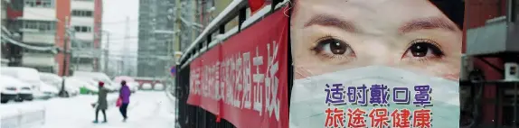  ??  ?? Un manifesto che informa sulle misure per proteggere la popolazion­e dal coronaviru­s è stato affisso nei pressi dell’ingresso di un complesso residenzia­le a Pechino