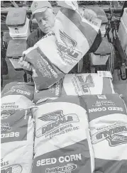  ?? Seth Perlman / Associated Press file ?? Farmer Gary Niemeyer readies his DeKalb seed corn for spring planting near Auburn, Ill. DeKalb is a product of crops and seeds specialist Monsanto.