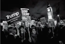  ?? ASSOCIATED PRESS ?? DEMONSTRAT­ORS HOLD PLACARDS AS THEY LISTEN to speeches in London on Monday during a rally in Parliament Square opposing U.S. President Donald Trump as Members of Parliament debate his planned state visit to the United Kingdom.