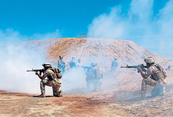  ??  ?? Coalition forces seen taking part in a training mission with Iraqi army soldiers at the Taji base, which was struck by multiple rockets.