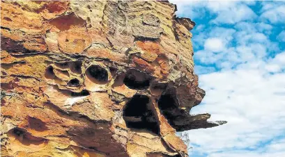  ?? JEANINE BARONE/ FOR THE WASHINGTON POST ?? Boldly hued cliffs are pocked with caves that serve as temporary burial chambers for the Bara tribe, in Isalo National Park.