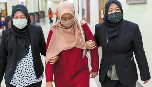  ?? ?? Off to court: nurul syafiha being led to the sessions Court where she pleaded not guilty to criminal breach of trust. — bernama