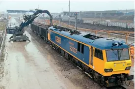  ?? ?? GBRf’s No. 92032 is used to demonstrat­e the new moveable equipment at Wellingbor­ough in appalling weather conditions on March 16. In this view the overhead system has been moved back to allow the wagons to be unloaded. Richard Gennis