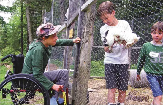  ?? PHOTOS MARTINE DOYON ?? Roméo présente un des lapins du clapier à son ami Elyjah, 13 ans, un Enfant Gioia. L’organisati­on permet à des enfants atteints de maladies incurables ou orphelines d’avoir accès à la nature et d’être moins surprotégé­s.