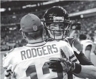  ?? AP PHOTO/DAVID GOLDMAN ?? The Green Bay Packers’ Aaron Rodgers hugs the Atlanta Falcons’ Matt Ryan before the NFC championsh­ip game on Jan. 22, 2017, in Atlanta. The stuggling Packers and Falcons play today at Lambeau Field.