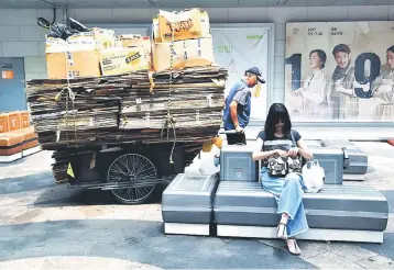  ??  ?? A man pulls a cart filled with cardboard boxes at a shopping district in Seoul. South Korea’s economic growth slowed in the past quarter, the central bank said yesterday, as a diplomatic row with top trading partner China over a US missile shield hit...