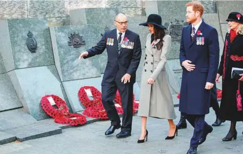  ?? Reuters ?? Britain’s Prince Harry and his fiancee Meghan Markle walk with New Zealand’s High Commission­er to the United Kingdom, Jerry Mateparae, at the Dawn Service at Wellington Arch to commemorat­e Anzac Day in London yesterday.