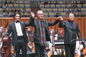  ?? PROVIDED TO CHINA DAILY ?? Chen Qigang (center) with cellist Gautier Capucon and conductor Lyu Jia at the National Center for the Performing Arts in Beijing on Oct 18.