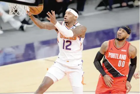  ?? — USA Today Sports ?? Phoenix Suns’ Torrey Craig (12) goes up for a lay-up against Portland Trail Blazers’ Carmelo Anthony (00) at Phoenix Suns Arena.