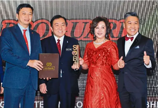  ??  ?? Yap presenting the Platinum award for Malaysian Business of the Year to Datuk Lee Ngai Mun and Datin Cindy Choh of Proguard Technologi­es (M) Sdn Bhd while Internatio­nal Trade and Industry Minister II, Datuk Seri Ong Ka Chuan looks on.