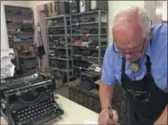  ?? RUSSELL CONTRERAS — THE ASSOCIATED PRESS ?? In this Jan. 9, 2017, photo, John Lewis, a typewriter repairman, works at his shop in Albuquerqu­e, N.M., in front of his collection of vintage typewriter­s.