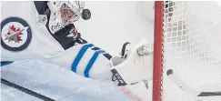  ??  ?? Winnipeg Jets’ Connor Hellebuyck is scored on by Calgary Flames’ Johnny Gaudreau in Edmonton on Saturday night.