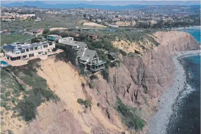  ?? Picture: AFP ?? ON EDGE. An aerial image shows homes along Scenic Drive crouching on a California clifftop above the Pacific Ocean after a landslide, following heavy rains in Dana Point.