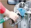  ?? — Reuters ?? A woman fills the car tank at a petrol station in Cairo.