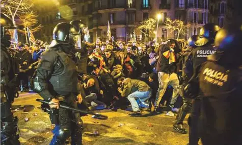  ?? Bloomberg ?? ■ Riot police armed with batons clash with protesters during demonstrat­ions in Barcelona, Spain, on Sunday, after the detention of former Catalan president Carles Puigdemont in Germany on Sunday.