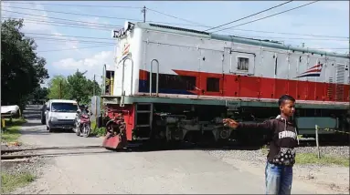  ?? BAGAS BIMANTARA/JAWA POS RADAR MADIUN ?? MANUAL: Lintasan kereta api tanpa palang pintu di Desa Kaliguntin­g dijaga warga sekitar dengan sukarela.