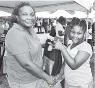  ?? CONTRIBUTE­D ?? Carlene Lamey, operations manager at Commercial Credit Investment­s, hands a bag with gifts, courtesy of Gifts Galore, to Jordena Gillespie, who will attend St Hilda’s Diocesan High School in September.