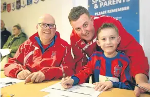  ??  ?? Dundee West held a signing evening for 6-8-year-olds at their Charlotte Street hub. Pictured are coach Ian Flight with Chris and Douglas Muir.