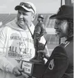  ??  ?? Mustangs coach Jon Kay shows off the MaxPreps national title trophy.