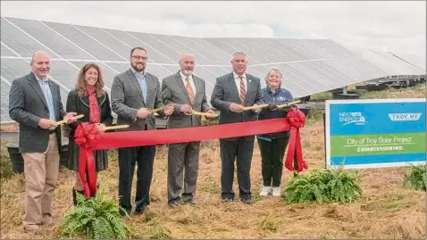  ?? Photos by Lori Van Buren / Times Union ?? Officials celebrate the end of Phase II of Troy’s solar energy array at the former Troy landfill Thursday. The panels can generate up to 2.6 megawatts of electricit­y daily to meet about half of the city government’s use of electricit­y.