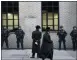  ?? MARK LENNIHAN - THE AP ?? In this Dec. 11 photo, Orthodox Jewish men pass New York City police guarding a Brooklyn synagogue prior to a funeral for Mosche Deutsch in New York. Deutsch, a rabbinical student from Brooklyn, was killed in the shooting inside a Jersey City, N.J. market.