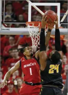  ?? GARY LANDERS — THE ASSOCIATED PRESS ?? Wichita State center Shaquille Morris (24) goes to the basket over Cincinnati guard Jacob Evans (1) during the first half Sunday. Wichita State bested the Bearcats, 76-72.