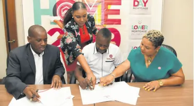  ?? CONTRIBUTE­D ?? From left: Vice-President of Sales and Service at the Victoria Mutual Group, Paul Elliott, looks on as Christophe­r ‘Johnny’ Daley signs on as Victoria Mutual’s chief happiness officer. Also pictured is Victoria Mutual Group Marketing Manager Keisha Mascoll and Assistant Manager Latoya Grindley (standing). Daley was signed to the new role on Tuesday at Victoria Mutual’s Half-Way Tree branch.