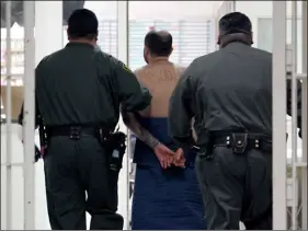  ?? AP PHOTO/RICH PEDRONCELL­I ?? In this Jan. 14, 2009, file photo, an inmate, on suicide watch, is escorted by correction­al officers at the California Substance Abuse Treatment Facility in Corcoran, Calif.
