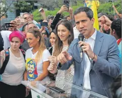  ??  ?? Arriba, el jefe de la Asamblea Nacional de Venezuela, Juan Guaidó, habla durante un evento ayer. A la derecha, sus simpatizan­tes y a la extrema derecha la cola para comprar gas en una colonia de Caracas