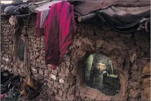  ?? ?? A child looks out of a window of his home Dec. 7 in a neighbourh­ood where many internally displaced people have been living for years in Kabul.