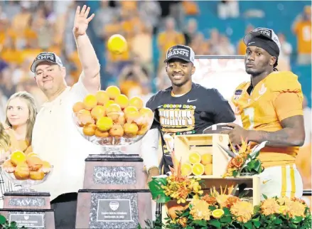  ?? AL DIAZ adiaz@miamiheral­d.com ?? Volunteers head coach Josh Heupel tosses oranges alongside injured quarterbac­k Hendon Hooker and quarterbac­k Joe Milton III after their win over Clemson. Milton took MVP honors after throwing for 251 yards on 19-of-28 passing with three touchdowns and no intercepti­ons.