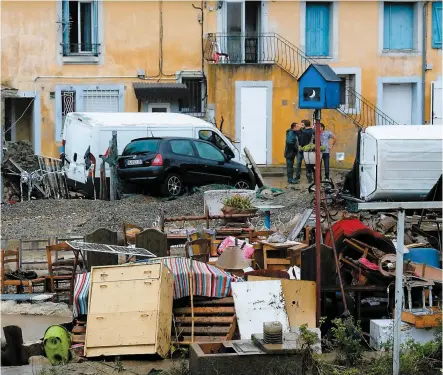  ??  ?? Des habitants de la petite commune de Trèbes, en France, tentaient de récupérer des meubles et des effets personnels hier après les inondation­s qui ont aussi provoqué des empilement­s de voitures. PHOTOS AFP