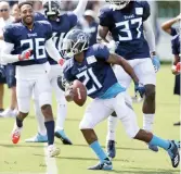  ?? Mark Humphrey/AP ?? ■ Tennessee Titans defensive back Malcolm Butler (21) runs back onto the field after making an intercepti­on during NFL football training camp Saturday, Nashville, Tenn. Butler says he still doesn’t know why he was benched by the Patriots in the Super...