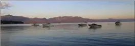  ?? MICHELLE LOCKE, THE ASSOCIATED PRESS ?? Boats ride at anchor in South Lake Tahoe as the morning sun turns the hills around the lake pink.