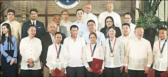  ?? JOVEN CAGANDE ?? President Duterte poses with Asian Games gold medalist weightlift­er Hidilyn Diaz, skateboard­er Margielyn Didal, golfer Yuka Saso, silver medalist boxer Rogen Ladon, sports officials and Cabinet members during the awarding of incentives to Asiad medalists at Malacañang yesterday. Story on Page 13.