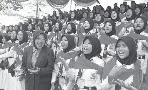  ?? DITE SURENDRA/JAWA POS ?? DEKAT SISWA: Wali Kota Surabaya Tri Rismaharin­i bernyanyi bersama siswa-siswi SMPN 3 Surabaya setelah upacara peringatan Hardiknas di Taman Surya kemarin (2/5).