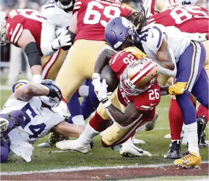  ?? LACHLAN CUNNINGHAM Getty Images ?? San Francisco’s Tevin Coleman lunges for a touchdown against Minnesota’s Anthony Harris in the second half of the NFC Divisional Round Playoff game Saturday as the top-seeded 49ers advanced to the NFC Championsh­ip Game against either Green Bay or Seattle.