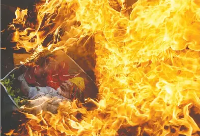  ?? ARIF ALI / AFP / GETTY IMAGES ?? Protesters burn a picture of Indian Prime Minister Narendra Modi in Lahore on Friday. Also on Friday, the United Nations Security Council held a rare meeting on Kashmir after India
stripped the region of its autonomy, sparking a row with Pakistan, diplomats say.