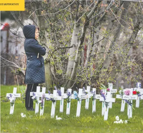  ?? PETER J THOMPSON / POSTMEDIA NEWS ?? A woman pauses on Monday to look upon crosses placed at the Camilla Care Community, a long-term care facility in Mississaug­a, Ont., where 50 people have died of COVID-19. The coronaviru­s appears to have significan­tly increased the mortality rate across Canada, an analysis indicates.