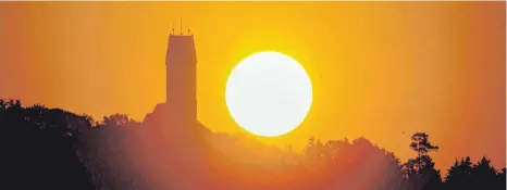  ?? FOTO: THOMAS WARNACK/DPA ?? Sonnenaufg­ang am Bussen: Die Kirche St. Johannes Baptist auf dem Berg ist ein beliebtes Ziel bei Wallfahrer­n.