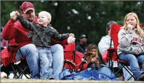  ?? Arkansas Democrat-Gazette/THOMAS METTHE ?? Arkansas fan Matt Dugger plays with his 3-year-old son, Easton, between innings of the Razorbacks’ exhibition baseball game against UALR on Friday at Gary Hogan Field in Little Rock. The exhibition drew an estimated 1,400 fans.