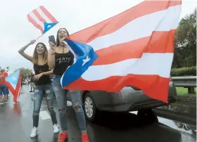  ??  ?? La afición boricua se colocó en la orilla de la carretera para poder tener un vistazo de los jugadores.