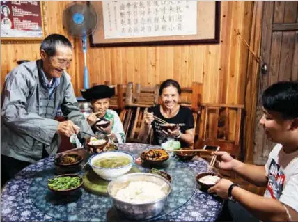  ??  ?? Shi Chengfu (left) has lunch with his family in Shibadong village on June 29.